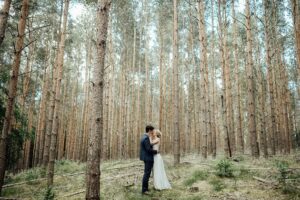 Bride and groom kissing in the woods