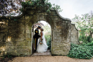 A bride and groom standing in a stone arch at Rufflets St Andrews