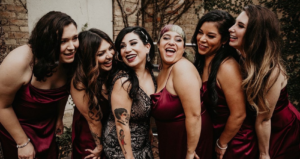 Blog Header For Black Wedding Dresses Blog With Bride Wearing A Dress Called Elaine By Maggie Sottero Standing With Bridesmaids Wearing Scarlet