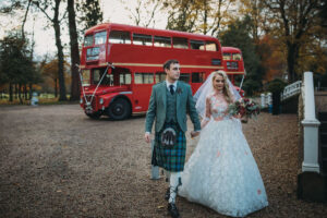 A bride and groom walking away from The Red Bus