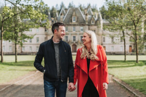 A man and woman walking hand-in-hand at Callendar Park in Falkirk