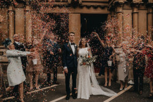 A bride and groom confetti shower photo by The Vedrines