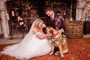 A bride and groom with their bull mastiff dog