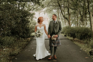a-bride-and-groom-walking-down-drive-at-Cornhill-Castle
