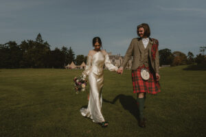 a bride and groom walking in the grounds at Hartree Estates