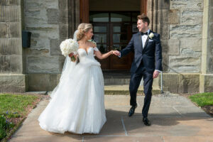 a bride wearing a martina liana wedding dress with a groom wearing a black dinner suit outside St Peters & St Andrews Church in Thurso
