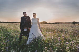 bride and groom in a field of flowers