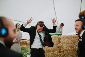 A person dancing next to hay bales at a Silent Knights silent disco