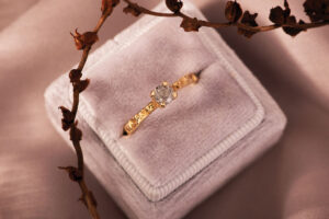 a gold and diamond ring in a grey velvet box by Islewear