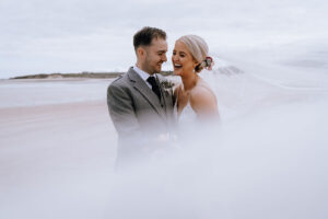 laughing bride and groom on the beach in the Isle of Lewis