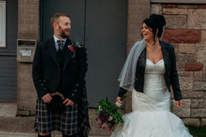 a bride and groom laughing outside The Hazel Arms pub